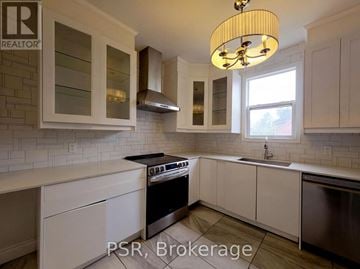 Kitchener apartment for rent - A kitchen with white cabinets and a black stove top oven.