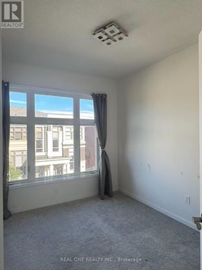 Markham (Wismer) townhouse for rent - A room with a window and a grey carpet.