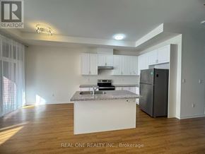Markham (Wismer) townhouse for rent - A kitchen with white cabinets and a granite countertop.