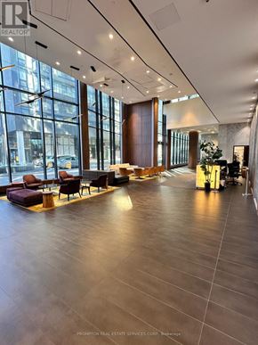 Toronto (Waterfront Communities) condo for rent - A spacious waiting area with a long wooden table and chairs.