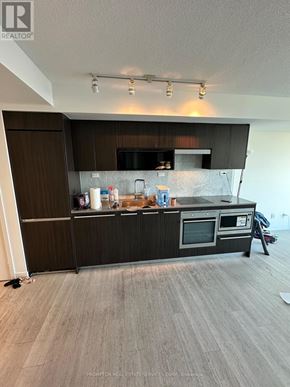 Toronto (Waterfront Communities) condo for rent - A kitchen with a black countertop and stainless steel appliances.