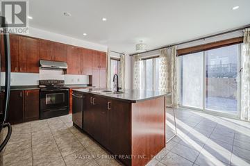 Aurora apartment for rent - A kitchen with brown cabinets and a black stove top oven.