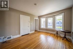 Windsor apartment for rent - A room with a wooden floor and a window with a view of a blue house outside.