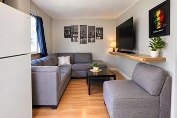 Gatineau (Hull) apartment for rent - A living room with a grey couch, a black coffee table, and a television on a wooden shelf.