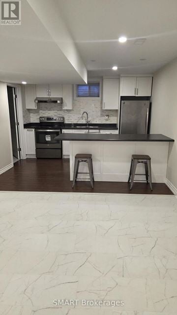 Richmond Hill (Mill Pond) apartment for rent - A kitchen with a black stove top oven and a black refrigerator.