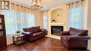 Oakville (Bc Bronte Creek) apartment for rent - A living room with two brown leather couches and a fireplace.