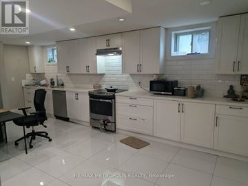 Toronto (Dorset Park) apartment for rent - A white kitchen with a black chair and a window.