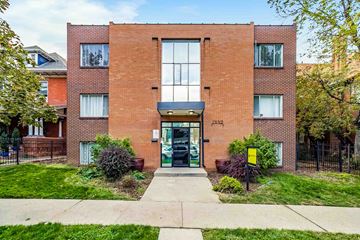 Denver apartment for rent - A red brick building with a glass door and windows.