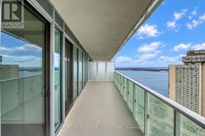 Toronto (Waterfront Communities) condo for rent - A balcony with glass railings overlooks a body of water.