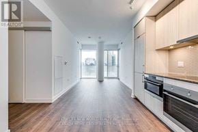 Toronto (Waterfront Communities) condo for rent - A spacious kitchen with wooden floors and modern appliances.