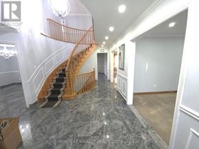 Toronto (West Humber-Clairville) apartment for rent - A spacious hallway with a marble floor and a wooden staircase.