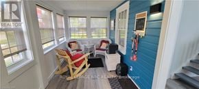 Fort Erie (Crystal Beach) apartment for rent - A sunny room with a blue wall and a white chair.