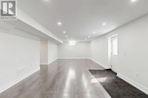 Pickering apartment for rent - A spacious room with a grey carpet and wooden flooring.