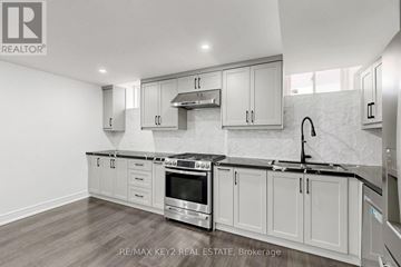 Pickering apartment for rent - A modern kitchen with white cabinets and stainless steel appliances.