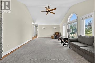 Essa apartment for rent - A spacious living room with a grey sofa and a ceiling fan.