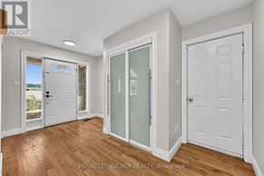 Essa apartment for rent - A room with a white door, a white wall, and a wooden floor.