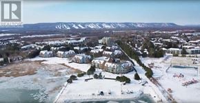 Collingwood condo for rent - A winter scene with a lake and houses.