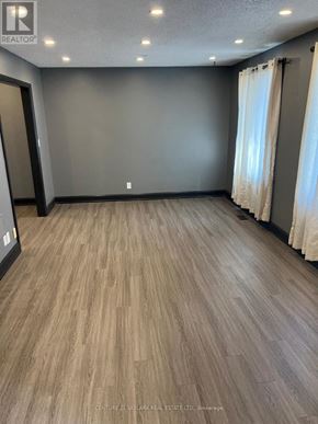 Clarington (Courtice) apartment for rent - A room with wooden flooring and a grey wall.