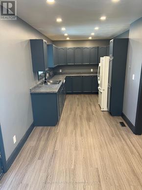 Clarington (Courtice) apartment for rent - A kitchen with a refrigerator, sink, and cabinets.