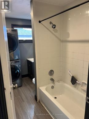Clarington (Courtice) apartment for rent - A bathroom with a tub, shower, and washing machine.
