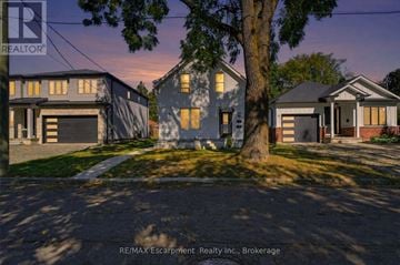 Brantford multi-family for rent - A REALTOR logo is on a sign in front of a house.
