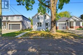 Brantford multi-family for rent - A white house with a tree in front of it.