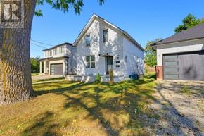 Brantford multi-family for rent - A white house with a tree in front of it.