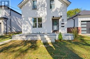 Brantford multi-family for rent - A white house with a black door and windows is shown.