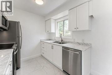 Cambridge apartment for rent - A kitchen with white cabinets and a marble countertop.
