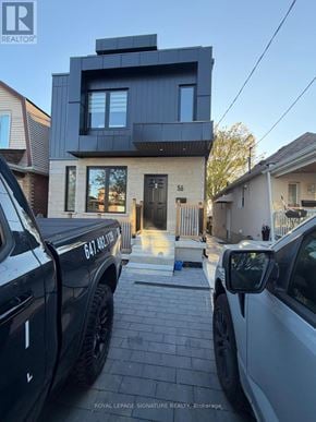 Toronto (Briar Hill-Belgravia) apartment for rent - Two trucks are parked in front of a modern house.