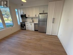 Toronto (Briar Hill-Belgravia) apartment for rent - A kitchen with white cabinets and a stainless steel refrigerator.