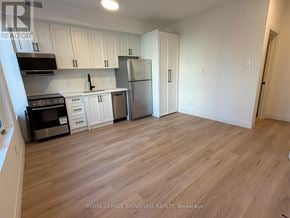 Toronto (Briar Hill-Belgravia) apartment for rent - A kitchen with white cabinets and a refrigerator.