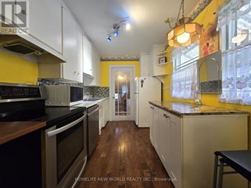 Hamilton (Eastmount) apartment for rent - A kitchen with wooden floors and white cabinets.