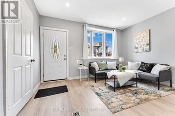 Hamilton (Landsdale) apartment for rent - A well-lit living room with a grey sofa and a white door.