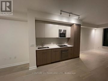Toronto (Oakwood Village) condo for rent - A kitchen with wooden cabinets and a microwave built into the cabinetry.