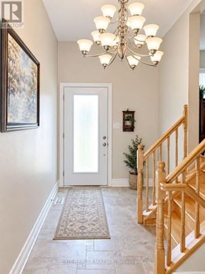 Casselman duplex for rent - A hallway with a chandelier, a door, and a staircase.