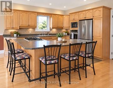 Casselman duplex for rent - A kitchen with wooden cabinets and a stainless steel refrigerator.