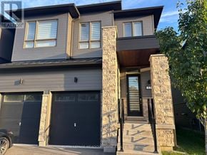 Wasaga Beach townhouse for rent - A modern house with a stone pillar entrance.