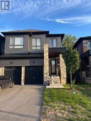 Wasaga Beach townhouse for rent - A modern house with a grey facade and a car parked in front.