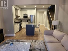 Wasaga Beach townhouse for rent - A modern kitchen with a dining table and a couch.