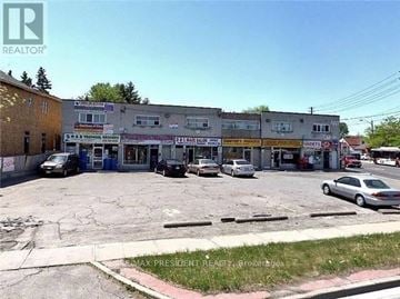 Toronto (Elms-Old Rexdale) apartment for rent - A parking lot with a building in the background and a car parked in front of it.