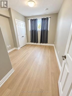 St. Catharines (Carlton/Bunting) duplex for rent - A room with a white door and a window with blue curtains.
