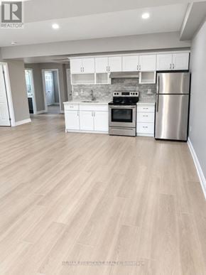 St. Catharines (Carlton/Bunting) duplex for rent - A kitchen with white cabinets and a stainless steel refrigerator.