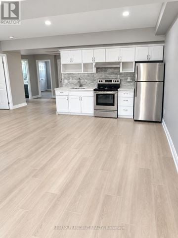 St. Catharines (Carlton/Bunting) duplex for rent - A kitchen with white cabinets and a stainless steel refrigerator.
