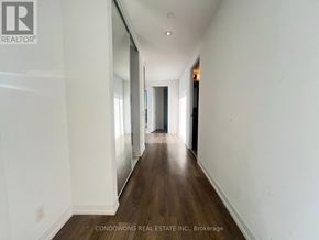 Vaughan (Vaughan Corporate Centre) condo for rent - A long hallway with white walls and wood flooring.