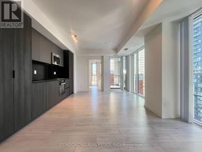 Toronto (Waterfront Communities) condo for rent - A spacious, modern kitchen with dark wood cabinets and a large island.