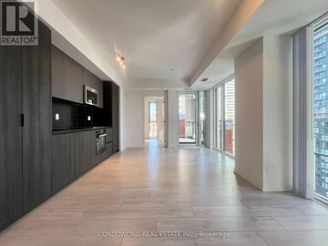 Toronto (Waterfront Communities) condo for rent - A spacious, modern kitchen with dark wood cabinets and a large island.
