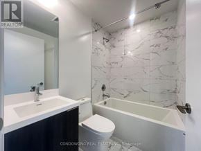 Toronto (Waterfront Communities) condo for rent - A bathroom with a marble tile wall and a bathtub.
