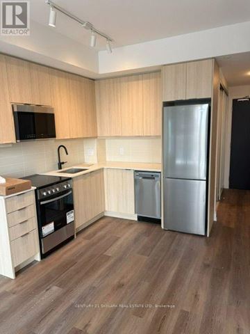 Milton (Tm Timberlea) condo for rent - A kitchen with wooden cabinets and a stainless steel refrigerator.
