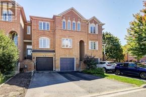 Oakville (Wc Wedgewood Creek) townhouse for rent - A large brick house with a garage and a driveway in front.